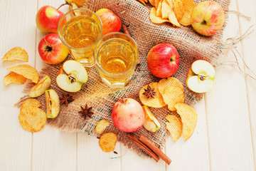 
apple cider with fresh apples , cinnamon , spices and chips on a wooden background
