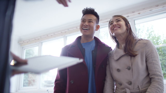  Young couple with real estate agent, looking at home to buy or rent