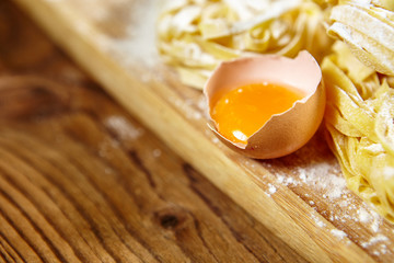 Raw homemade pasta and ingredients for pasta on wooden backgroun