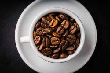 Cup full of coffee beans on the black table