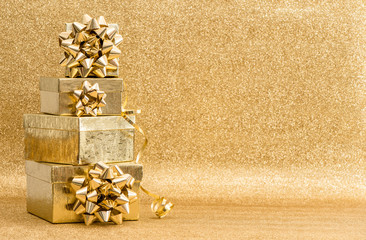 Gifts with ribbon bow on golden background