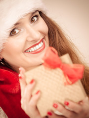 Woman in santa helper hat holds gift box