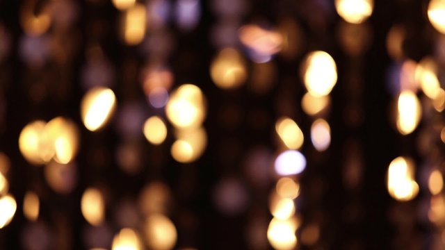 Abstract glittering lights, gold background, a real shot video in the blur