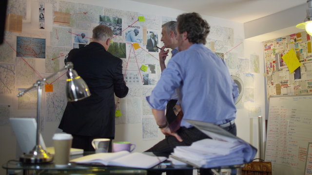  Police detectives working together in incident room to try and solve a case