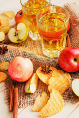 
apple cider with fresh apples , cinnamon , spices and chips on a wooden background