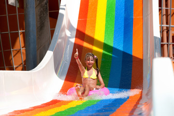 Child in bikini sliding water park.