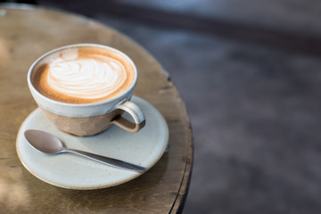 Hot art Latte Coffee in a cup and laptop on wooden table