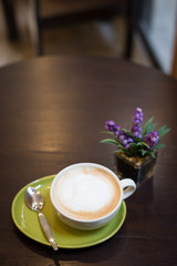 Hot art Latte Coffee in a cup and laptop on wooden table.
