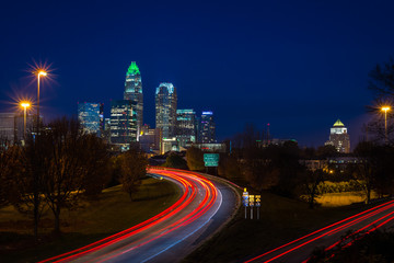 The top of the tallest tower in Charlotte, North Carolina lit up green in support of our military taken during the evening rush hour commute - 97971085