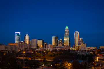 The top of the tallest tower in Charlotte, North Carolina lit up green in support of our military taken during the evening rush hour commute - 97971833