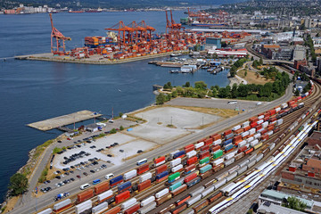 Obraz premium Ruchliwy port morski z pociągami kontenerowymi