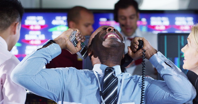 Financial traders in busy stock exchange celebrate making lots of money