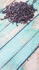 Black glutinous rice over wooden background