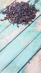 Fototapeta premium Black glutinous rice over wooden background