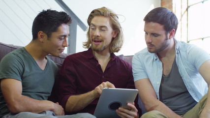 Student house accommodation. Flat share with young adults using digital tablet