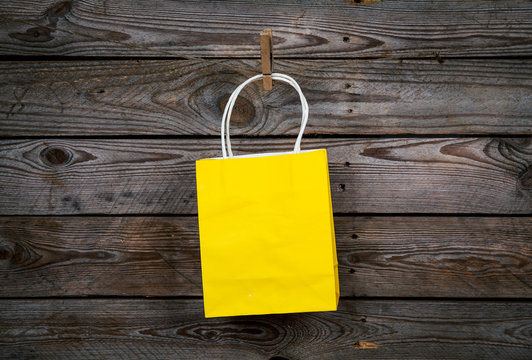 yellow Shopping bag on a wooden background, sale, purchase