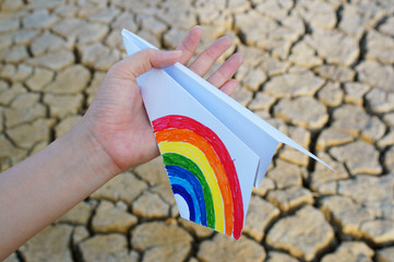 hand holding colorful paper airplane.