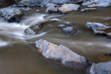 Naklejka na ściany i meble creek flowing over the rocks