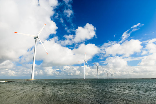 Numerous wind turbines standing in the sea on the Danish coast