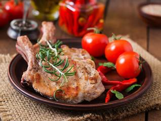 Grilled juicy steak on the bone with vegetables on a wooden background.