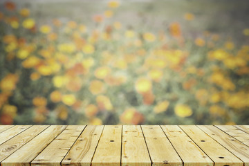 Wood table top on blurred flowers