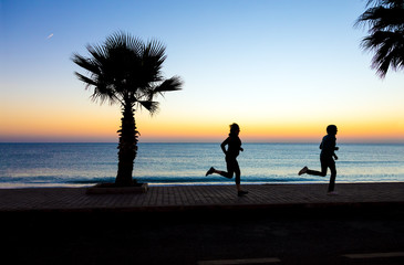 Man and Woman jogging on Seafront making Morning Fitness