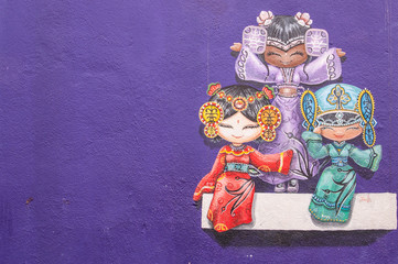 Obraz premium Sztuka uliczna „Trzy chińskie lalki na ścianie” na ścianie w George Town, Penang, Malezja.