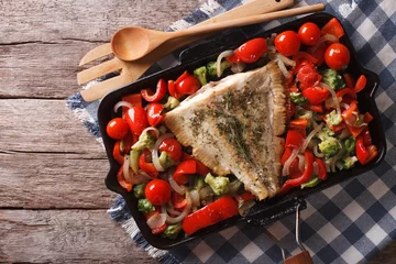 Fotobehang flounder with vegetables on a frying pan. Horizontal top view   © FomaA