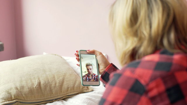 Girl chatting with her boyfriend on smartphone and having a videocall
