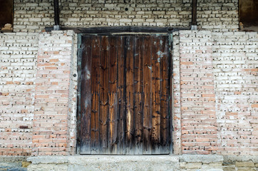 Old wooden gate at brick building