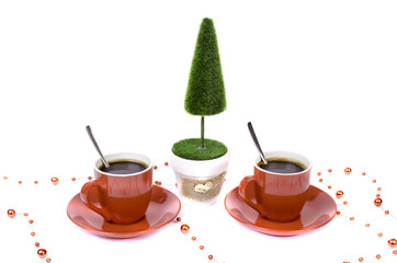 Two red cups of coffee tree and a basket of chocolate.