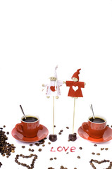 Two red cups of coffee, coffee beans and chocolate hearts.