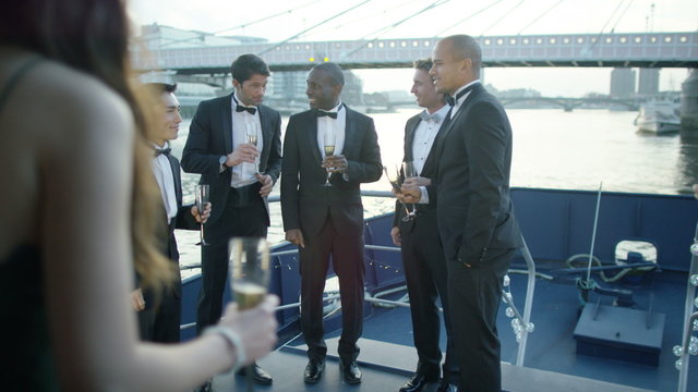  Happy diverse group of friends drinking champagne & having fun at boat party