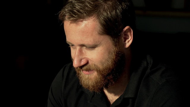 Man with ginger beard looking around and smiling
