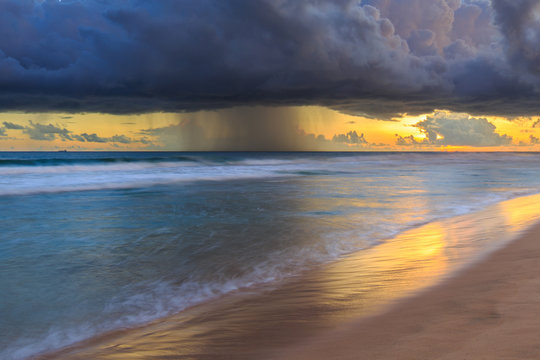 Seascape with dark rain clouds at sunset