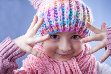 Little girl in knitted hat, scarf and mitten