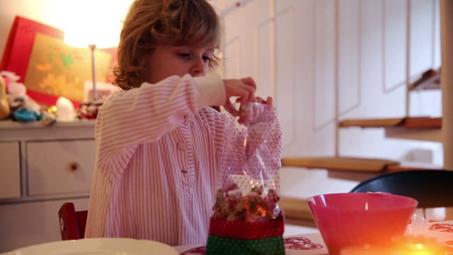A little girl is filling a sachet with cookies and treats on advent first