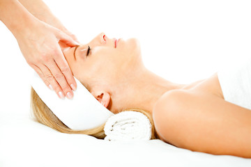 Young woman having forehead massage on spa treatment