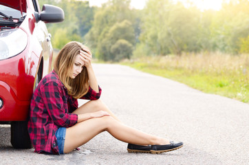 Young woman near broken car