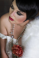 Single beautiful brunette girl 20s style flapper with jewels and