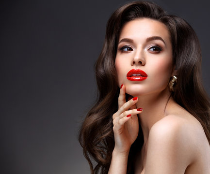 Beauty Model Woman with Long Brown Wavy Hair. Healthy Hair and Beautiful Professional Makeup. Red Lips and Smoky Eyes Make up. Gorgeous Glamour Lady Portrait. Haircare, Skincare concept