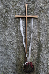 Bronzenes Kreuz mit Kranz auf Grabstein