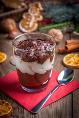 Layered dessert in a glass on a wooden table.