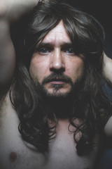 sexy naked man with long dark hair, intense eyes and blue eyes