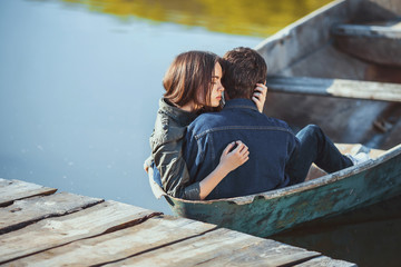 Happy romantic couple rowing a small boat on lake