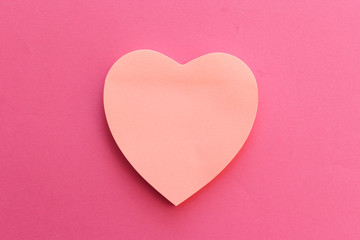 Blank pink paper note heart shape on pink background with copy space