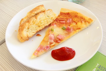 pizza slice and garlic bread on dish
