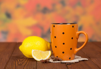 Cup of tea with lemon on autumn leaves