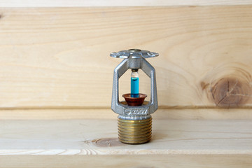 fire sprinkler with fire in wooden background.