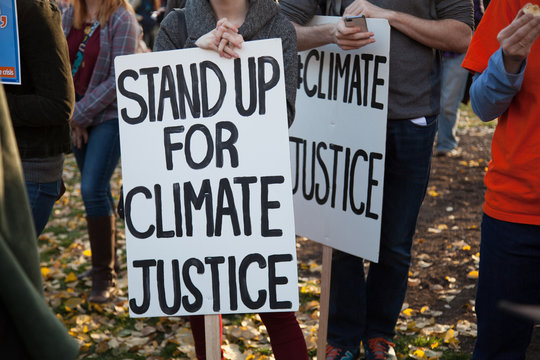 Stand up for climate justice two signs